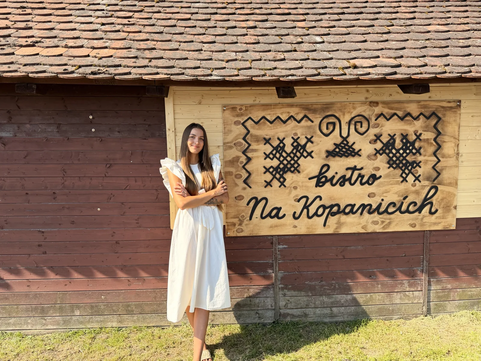 Ester Husaříková před cedulí bistro Na Kopanicích